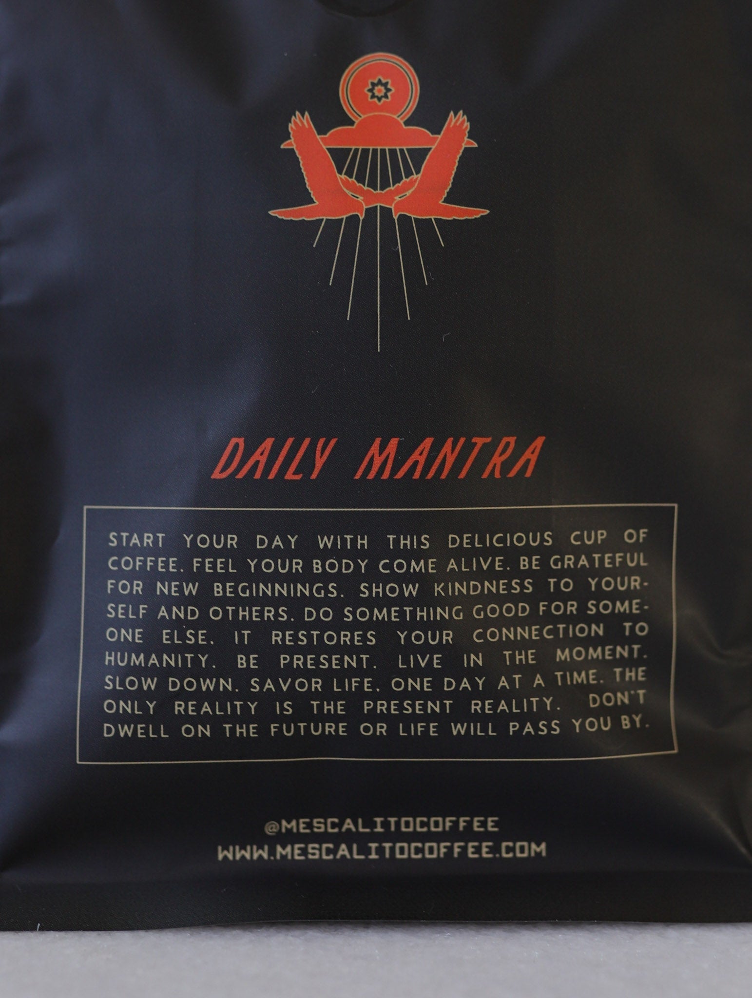 Close-up of Mescalito Coffee packaging reading "Daily Mantra" with mindful, kind instructions—featuring Single Origin Whole Coffee Beans, Magnolia, medium roast Guatemala (washed). Visit mescalitocoffee.com.